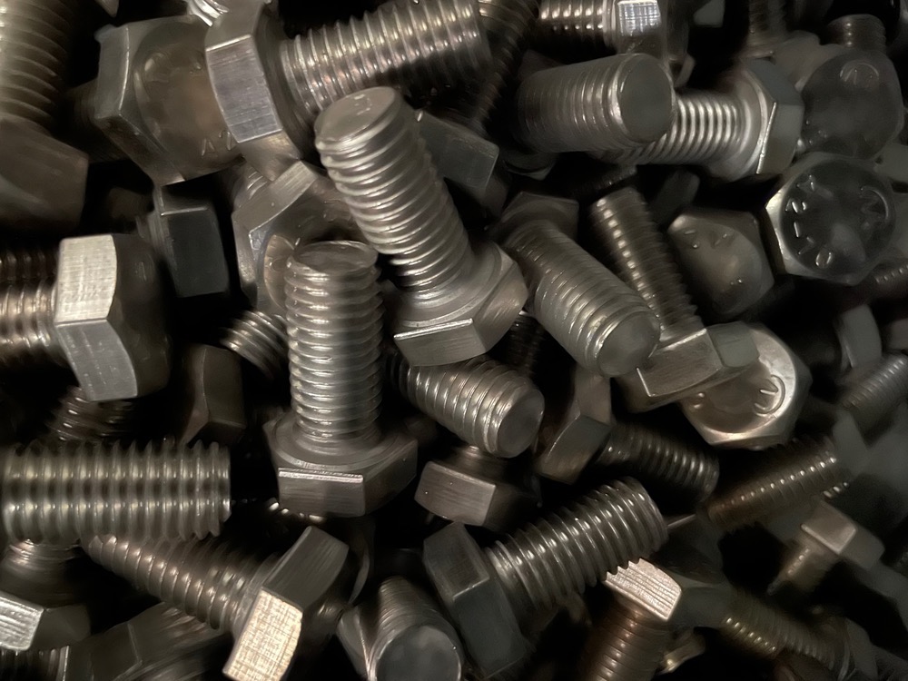 عکس صنعتی واقعی پیچ و مهره عمده روی سطح فلزی - Pichstore